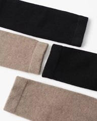 Two pairs of black and beige socks on a white background